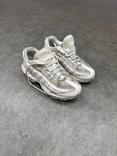 A worn pair of white Nike Air Max 95 sneakers before restoration