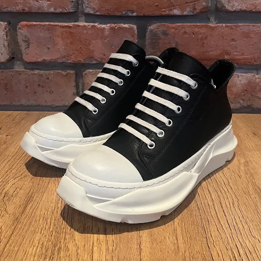 Black leather low-top sneakers with chunky white soles
